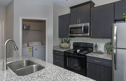a kitchen with granite counter tops and black and white appliances