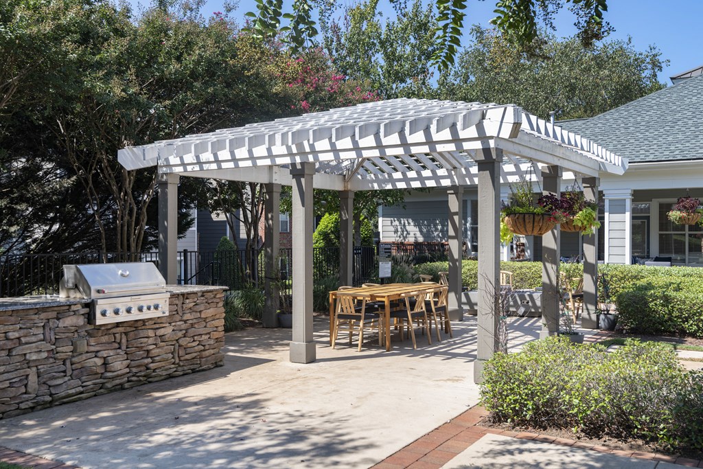 a pergola with a table and chairs under it
