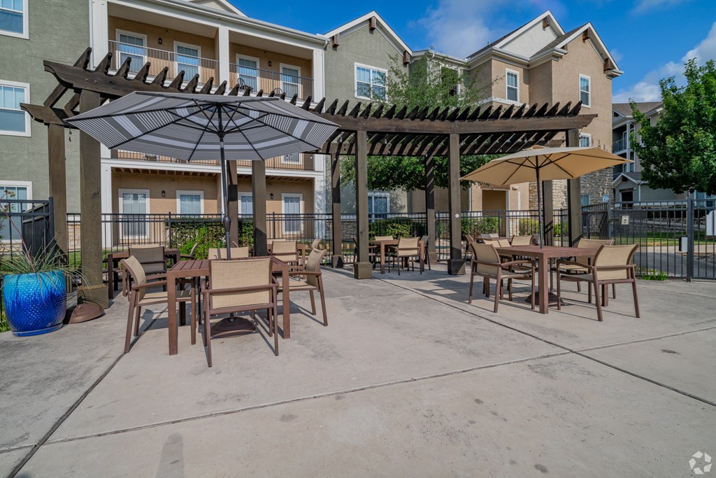 A patio with a table and chairs under a canopy.