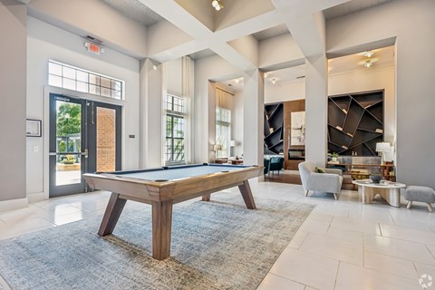 A pool table is in the middle of a room with a blue rug.