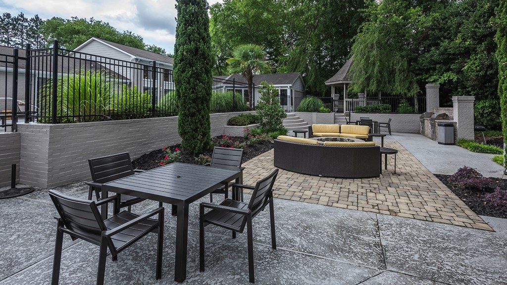 a patio with a table and chairs and a fire pit