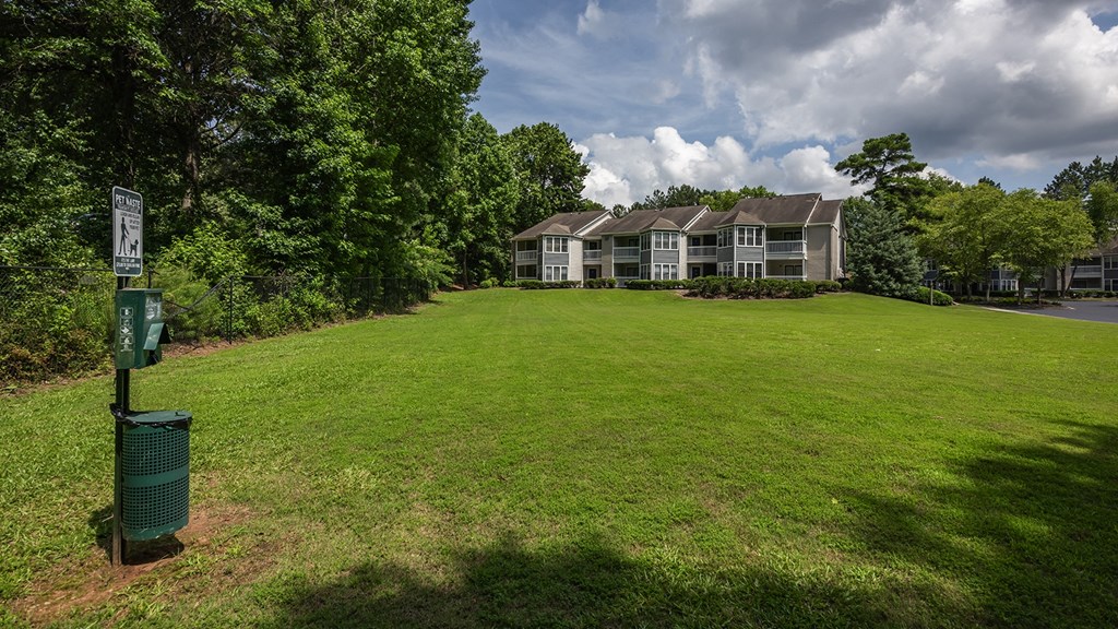a green lawn in front of a house with a green mailbox