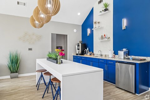 A kitchen with a white island and blue cabinets.