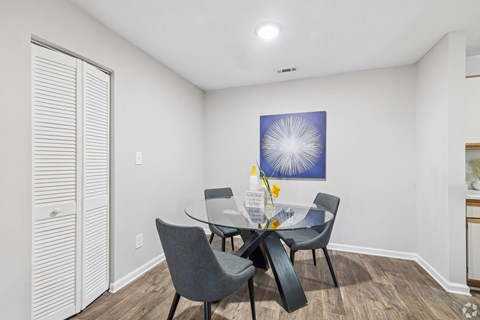 A dining room with a table and chairs.