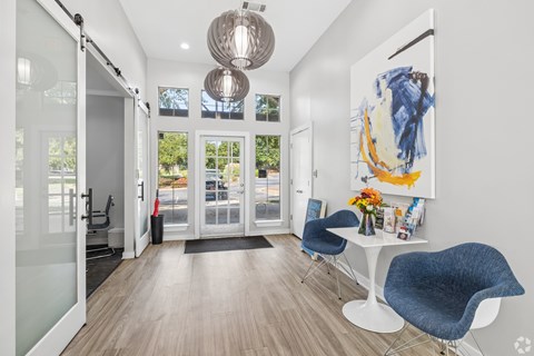 A modern room with a white table and blue chairs.