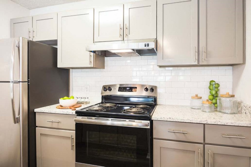 Renovated kitchen with stainless steel appliances and gray cabinets at Eclipse Apartments
