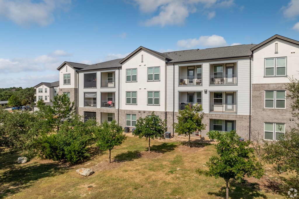 Apartment complex with trees in front.