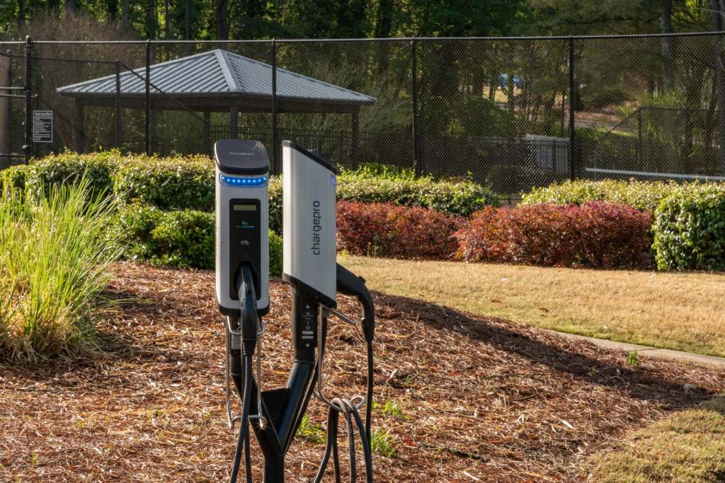 Veridian at Sandy Springs apartments power station in a park with a fence and a gazebo in the background