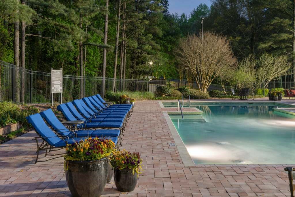Veridian at Sandy Springs apartments resort pool with blue lounge chairs and potted plants