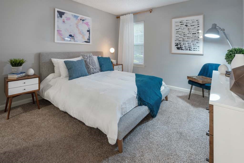 Veridian at Sandy Springs apartments interior bedroom with a bed and a desk with a chair