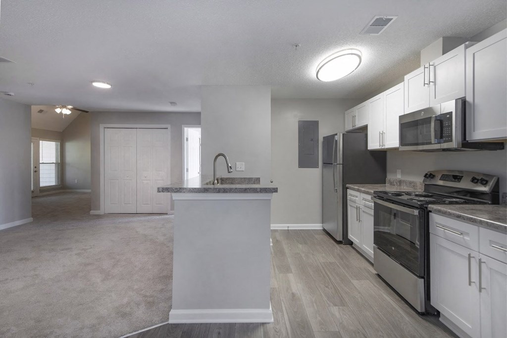 A kitchen with white cabinets and stainless steel appliances.