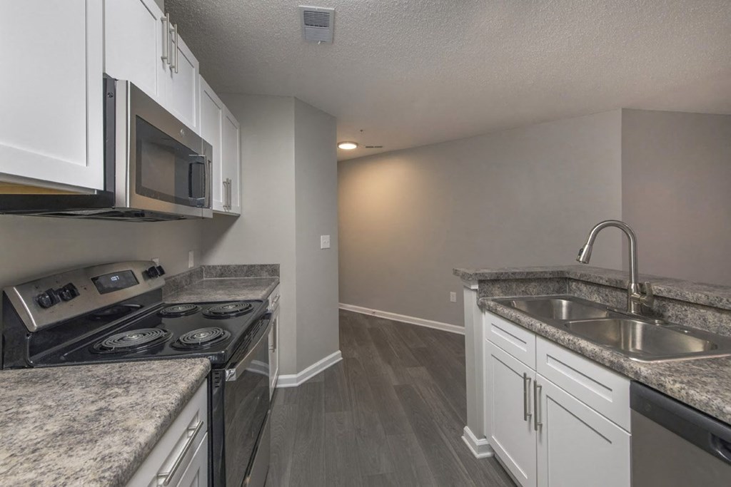 A kitchen with granite countertops and stainless steel appliances.
