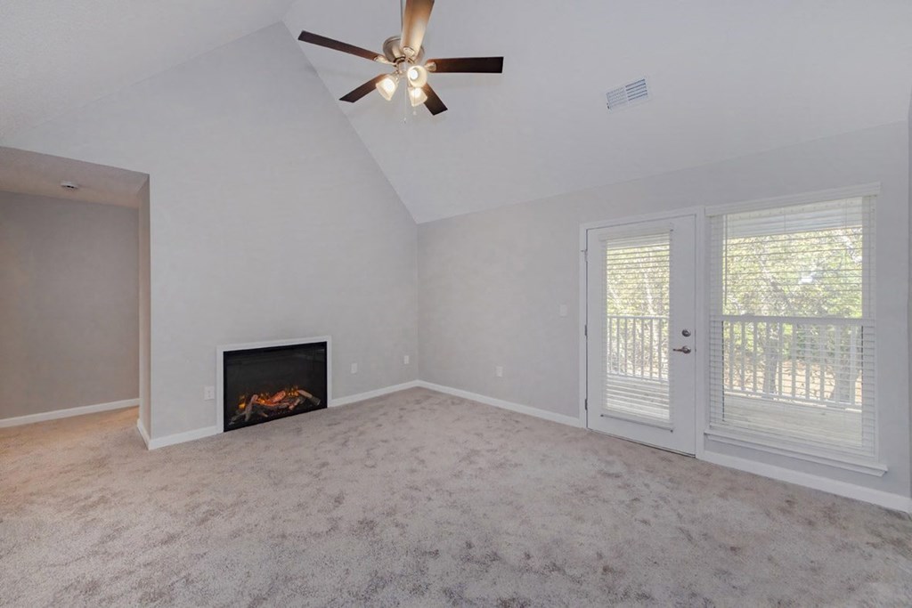 A room with a fireplace and a ceiling fan.
