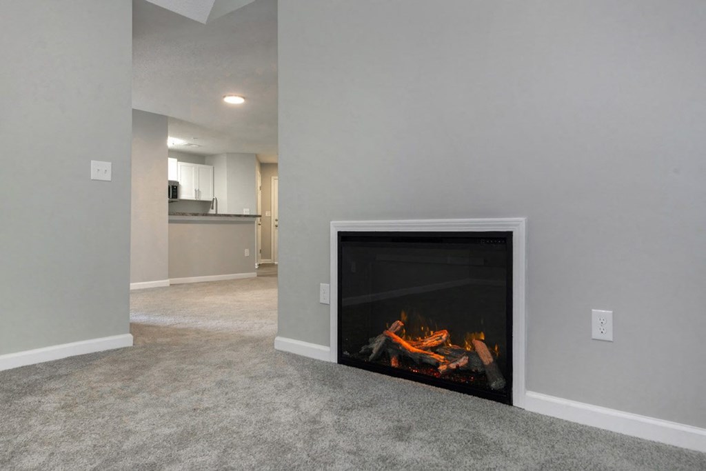 A modern living room with a fireplace and a carpeted floor.