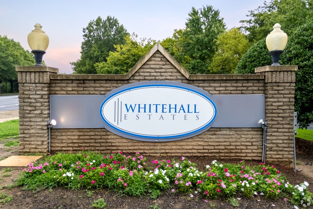 A sign that says Whitehall Estates is displayed in front of a building.