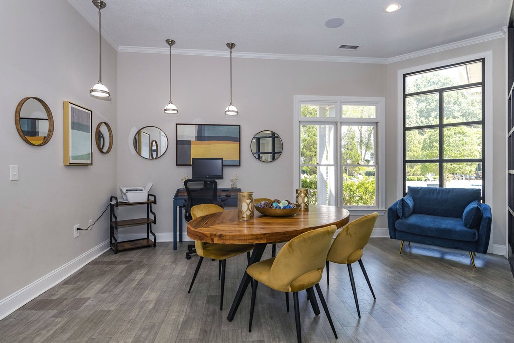 Business center for residents at Whitehall Estate apartments in Charlotte NC with gray walls and a wooden table with yellow chairs