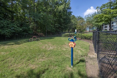 a post with a bark park sign in the middle of a fenced in off leash dog park at Wynnwood Vinings