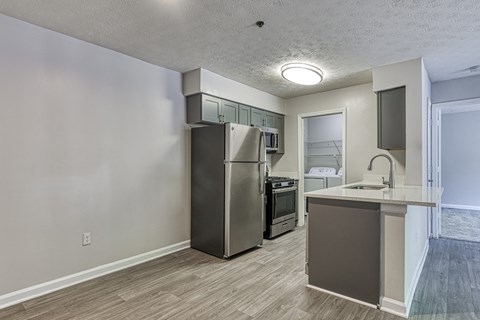 an empty kitchen with a stainless steel refrigerator and a counter top