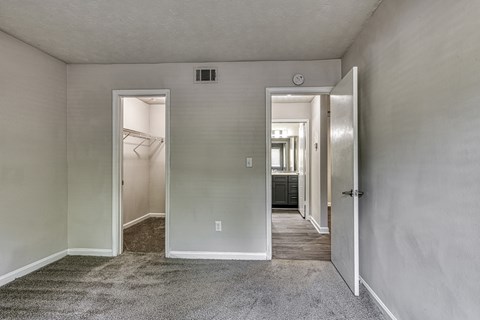 an empty bedroom in an apartment with a door to the walk in closet at Wynnwood Vinings