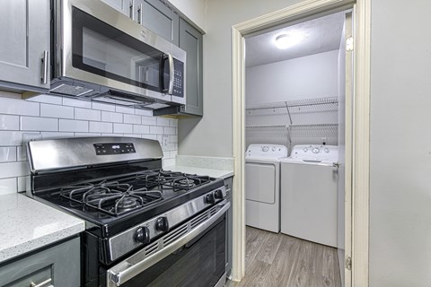 a kitchen view at Wynnwood Vinings with a stove and microwave and a washer and dryer
