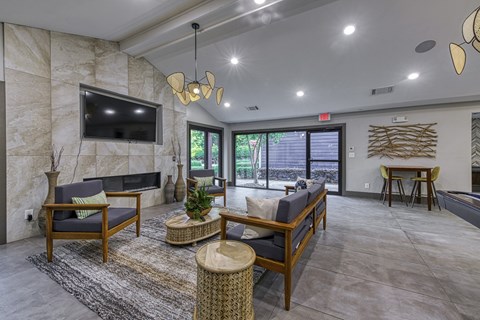 A living room with a flat screen TV mounted on a stone wall.