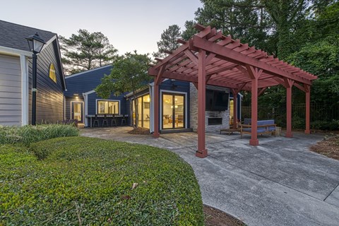 A house with a red pergola and a grey driveway.