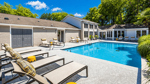 Duluth, GA, Apartments with In-Unit Washer and Dryer - The Eclipse - Swimming Pool With Lounge Chairs, Spacious Sundeck, Landscaped Surroundings, And Apartment Building.