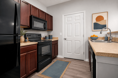 A kitchen with black appliances and wooden cabinets.