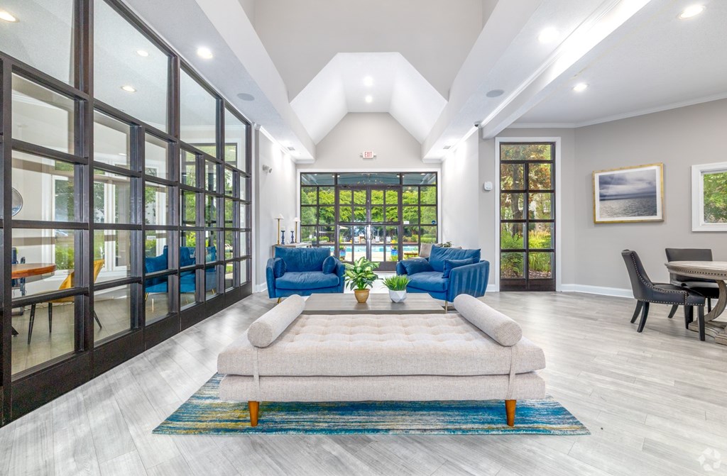 A modern living room with a large window and a view of the trees outside.