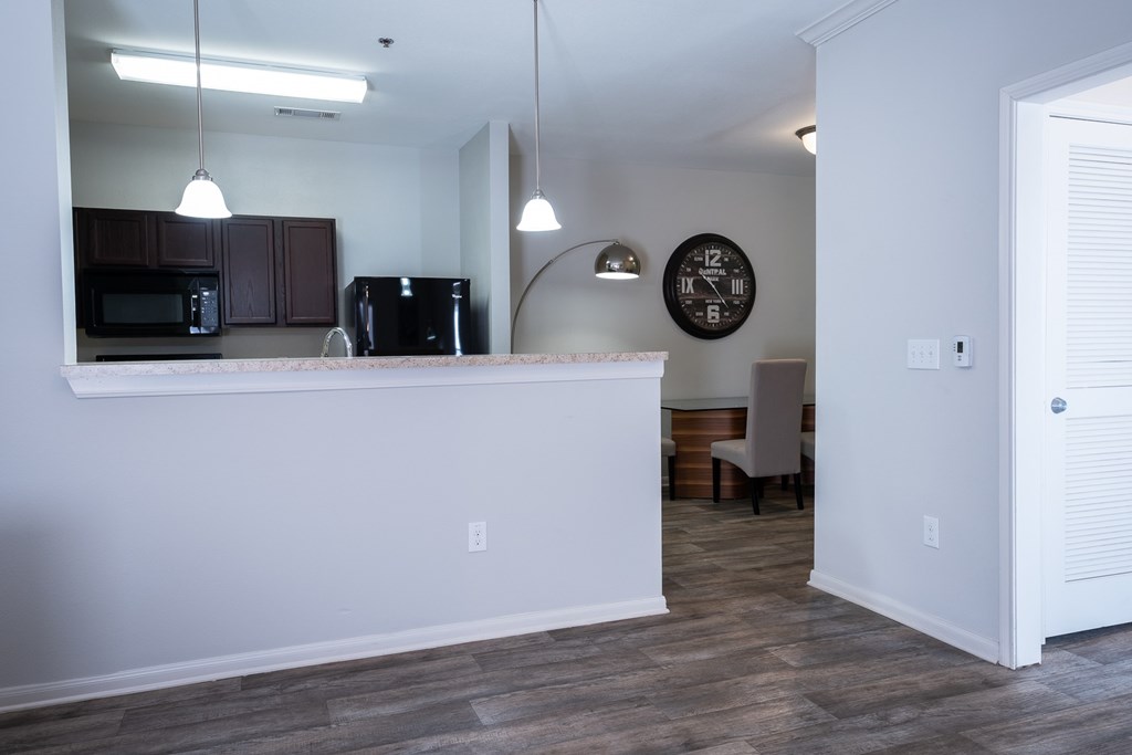 A kitchen with a white counter and a clock on the wall.