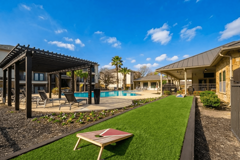 A backyard with a pool and a patio area.