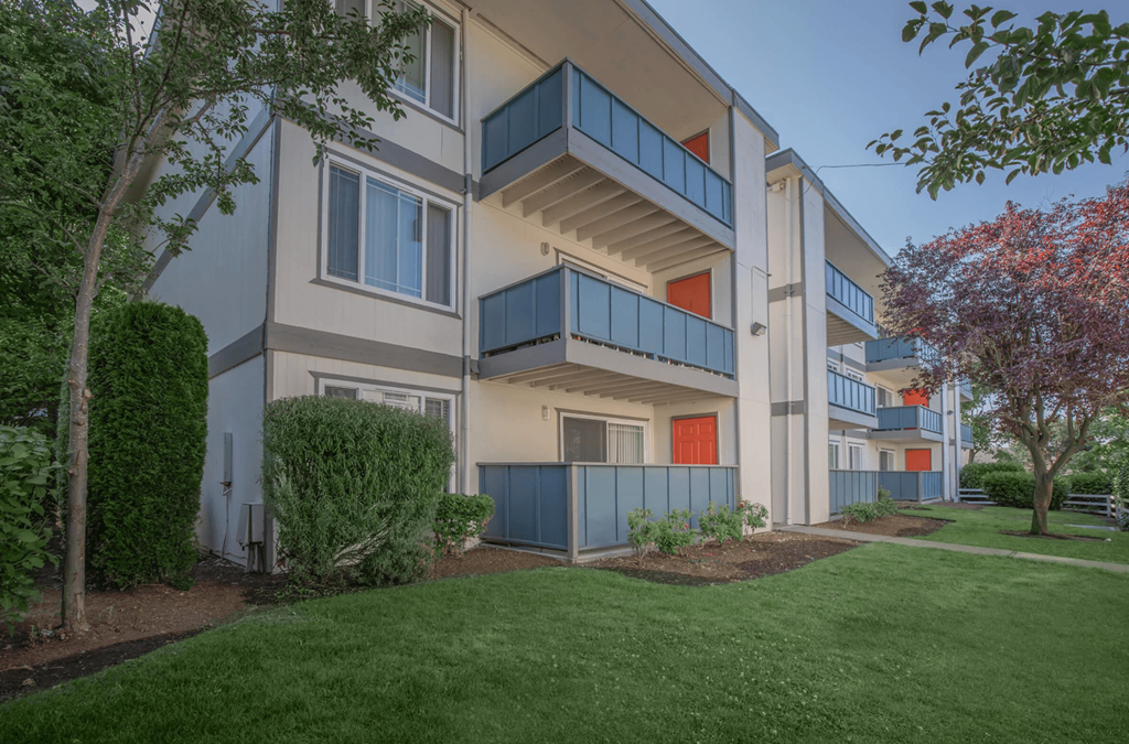 Tukwila, WA Apartments - Foster Creek - Exterior View of Apartment Building with Balconies Surrounded by Lush Landscaping