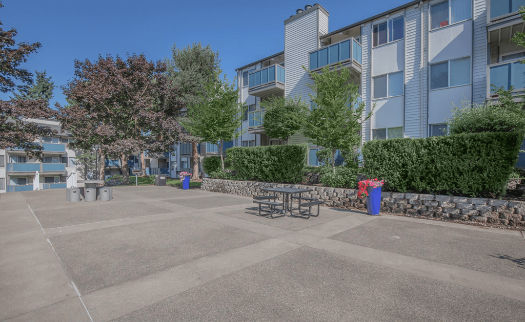 An open area outside of Foster Creek apartment homes with tables and space for outdoor lounging
