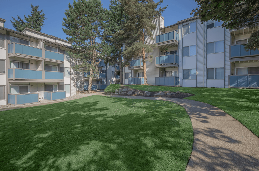 a grassy area with trees in a courtyard space at pet-friendly apartments in Tukwila