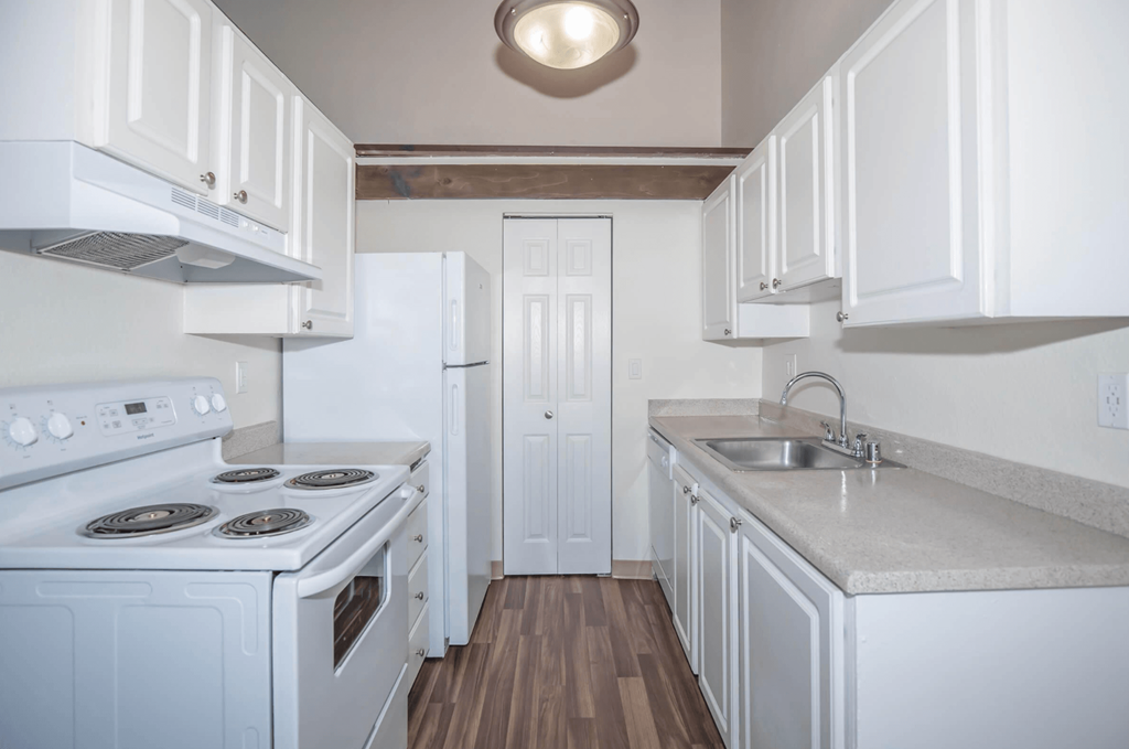 Renovated kitchen with white cabinets and all white appliances at Foster Creek apartments
