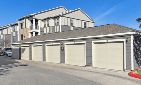 a garage with multiple doors in front of a house
