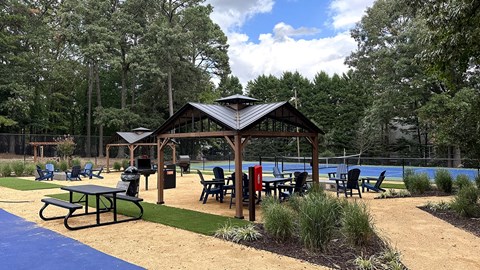 a picnic area with a pavilion next to a swimming pool