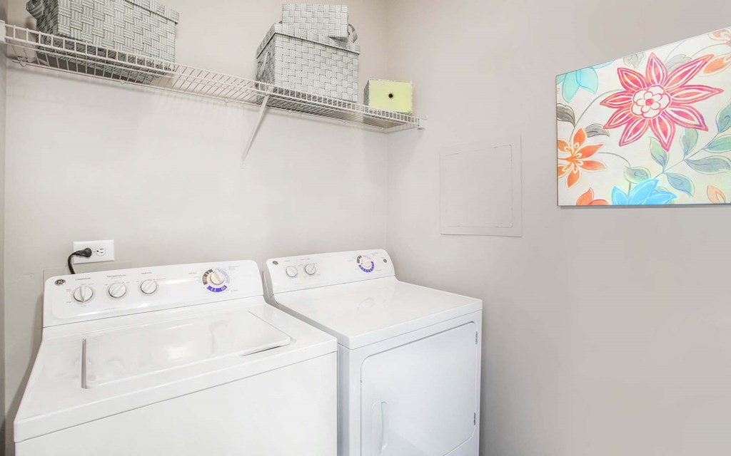 the washer dryer closet inside of an apartment at Seasons at Umstead apartments in Raleigh