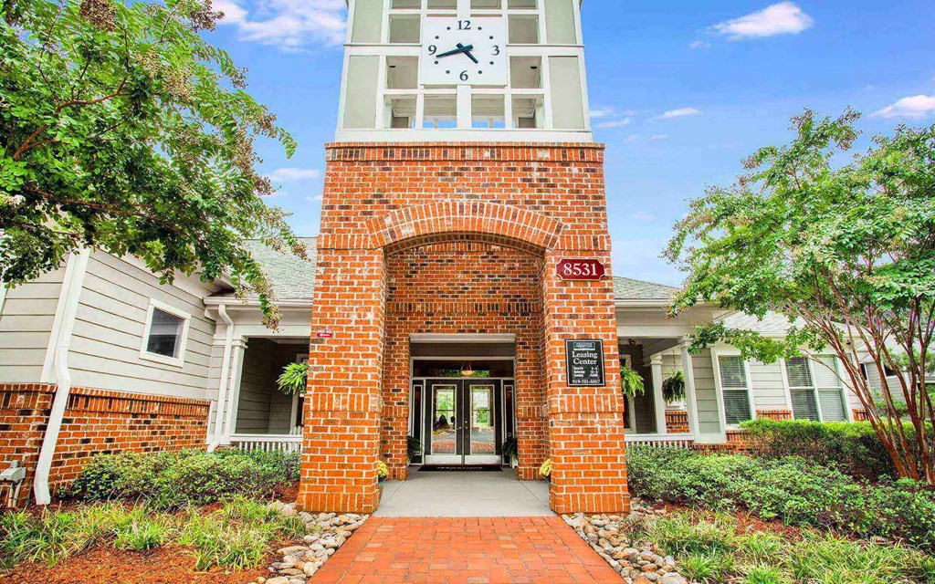 Entrance to leasing center at Seasons at Umstead apartments in Raleigh with clock tower and brick walls