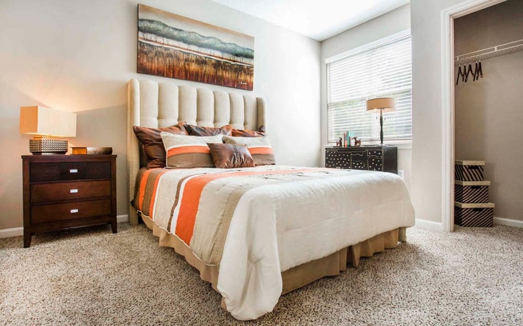 a bedroom at Seasons at Umstead apartments in Raleigh with a bed and two night stands
