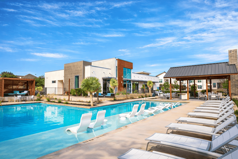 Three-Bedroom Luxury Apartments in North San Antonio, TX - Hardy Oak - Resort-Style Swimming Pool With Lounge Chairs, In-Water Loungers, Cabana, and Modern Clubhouse.
