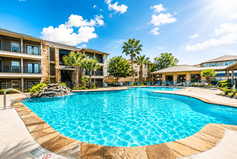 A large swimming pool in front of a resort building.