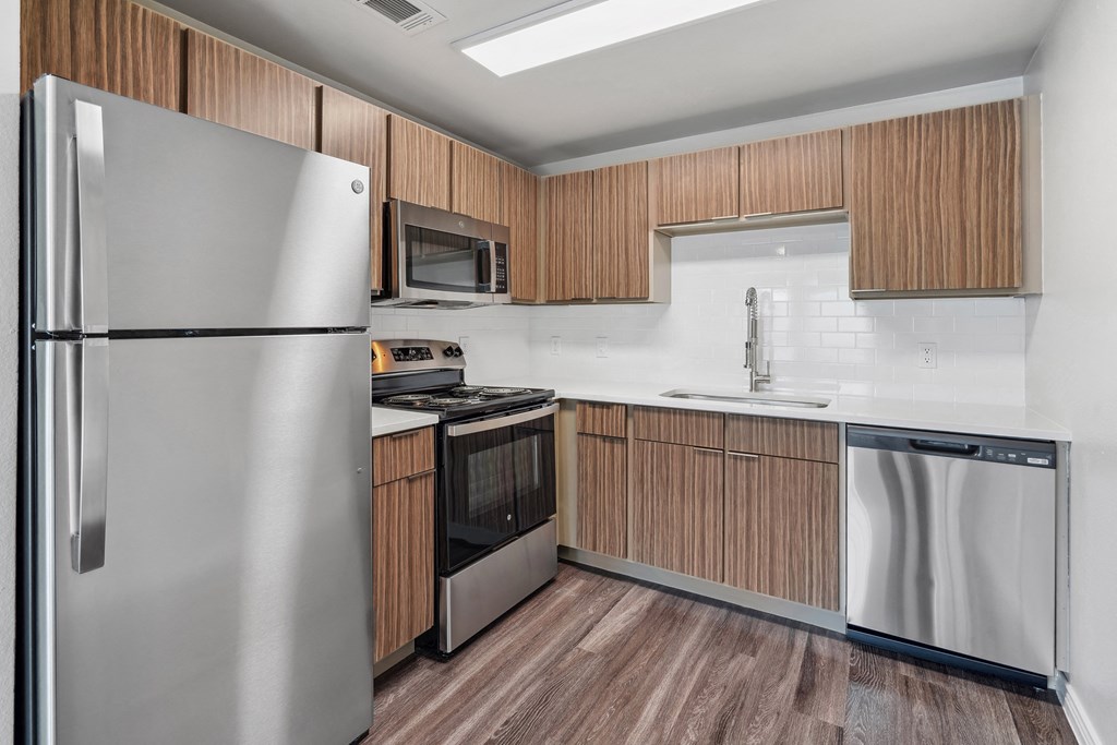 a kitchen with stainless steel appliances and wooden cabinets