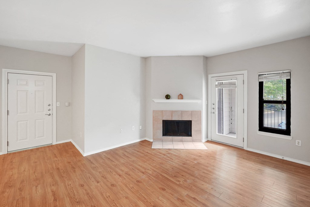 a bedroom with hardwood floors and a fireplace