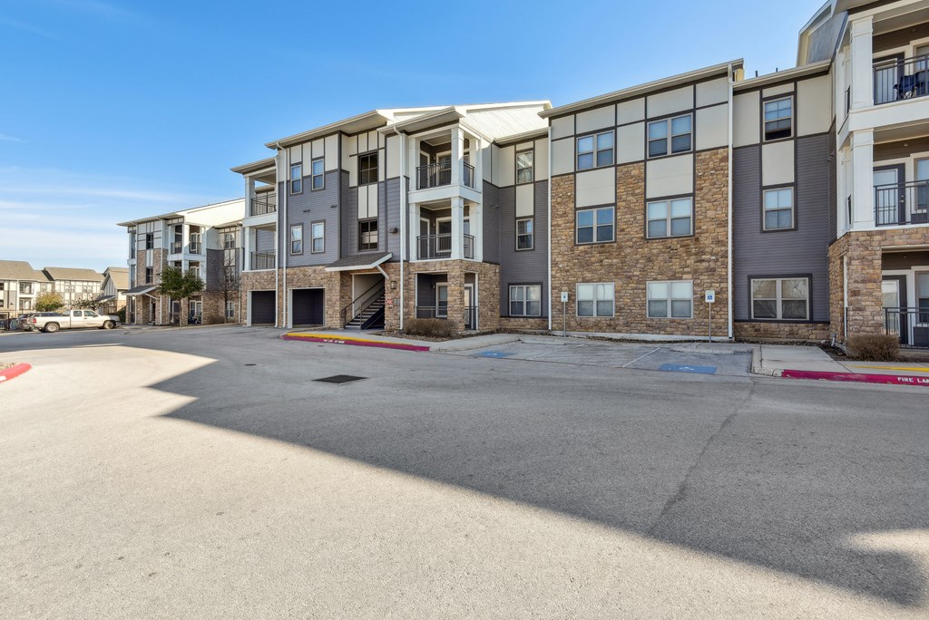 an empty parking lot in front of an apartment building