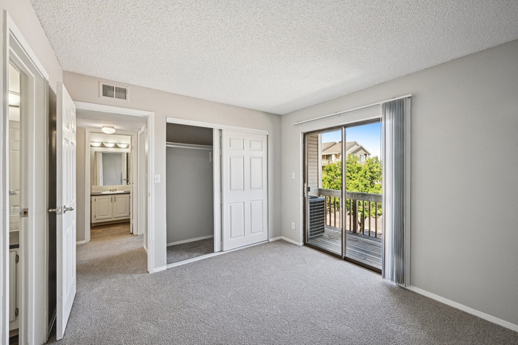 an empty living room with sliding glass doors to a balcony