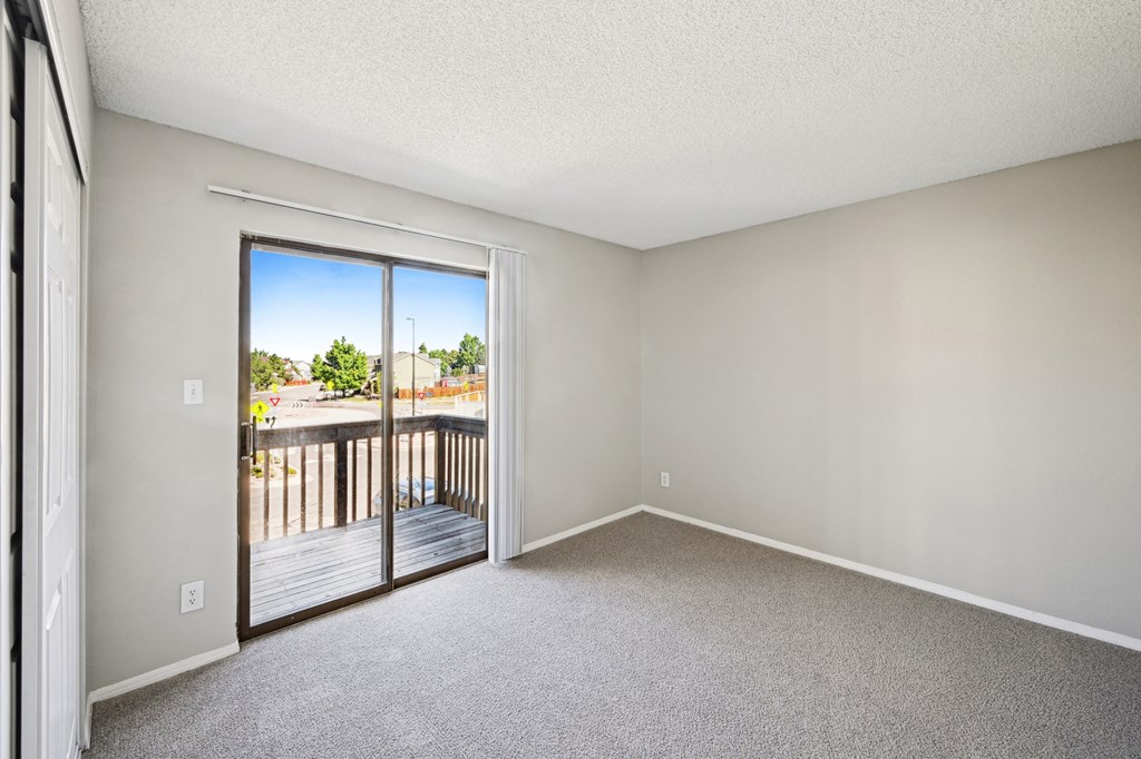 an empty bedroom with white walls and carpet