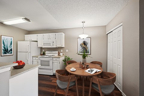 A kitchen with a table and chairs in the middle of it.