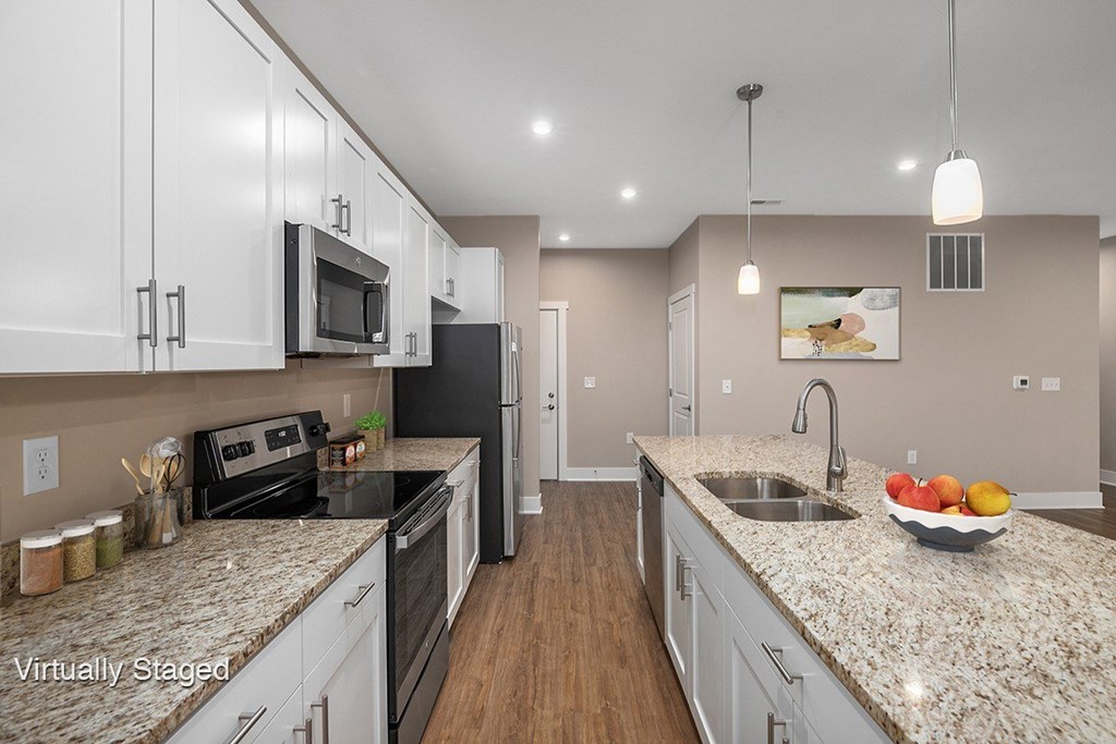 a large kitchen with granite counter tops and white cabinets