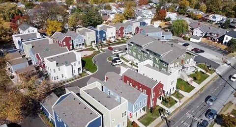 A bird's eye view of a residential area with houses and a road.